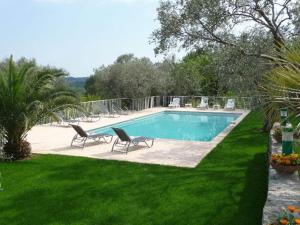 een zwembad met twee stoelen in een tuin bij Villa la Grette in Fayence