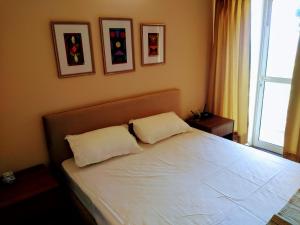 ein Schlafzimmer mit einem großen weißen Bett mit zwei Kissen in der Unterkunft Entire Condominium Luxury Suites Perfect Getaway in Noida