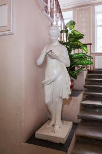 a statue of a woman standing next to a staircase at Итальянские комнаты и апартаменты Пио на Моховой 39 in Saint Petersburg