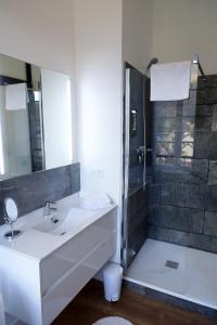 a white bathroom with a sink and a shower at Maison Eugénie in Luchon