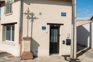 an old white building with a black door at Meublé de tourisme 3 étoiles Loft industriel à Fismes in Fismes