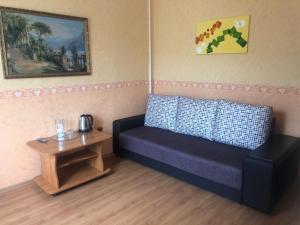 ジェレスノヴォツクにあるZhemchuzhina Kavkaza Hotelのリビングルーム(ソファ、テーブル付)