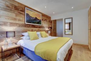 a bedroom with a bed and a wooden wall at Chalet La Petite Grange in Morzine