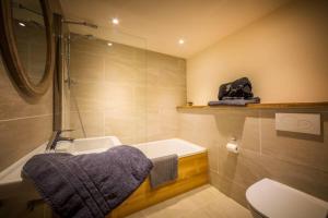 a bathroom with a tub and a sink and a toilet at Chalet La Petite Grange in Morzine