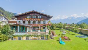 una grande casa con un cortile con parco giochi di Hettlerhof a Maishofen
