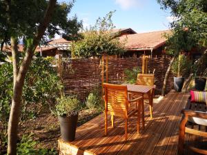 a wooden deck with two chairs and a table at la cabane vensac ocean montalivet in Vensac