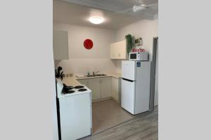 a kitchen with a white refrigerator and a stove at Walk to Lamberts Beach with Wi-fi and Netflix in Slade Point