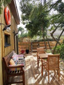 a patio with two chairs and a bench and a table at la cabane vensac ocean montalivet in Vensac