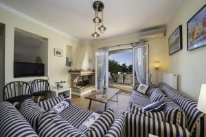 a living room with blue and white striped couches at Eglina Villa's in Minia