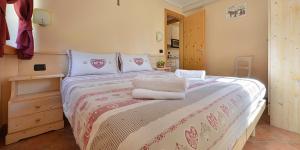 una camera da letto con un letto e asciugamani di APPARTAMENTI SAN GIOVANNI a Livigno