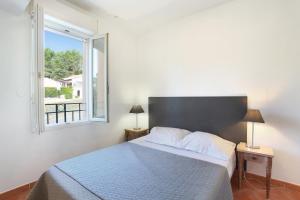 a bedroom with a bed with a large window at Résidence Odalys La Licorne de Haute Provence in Gréoux-les-Bains