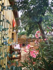 a patio with chairs and flowers and a fence at la cabane vensac ocean montalivet in Vensac