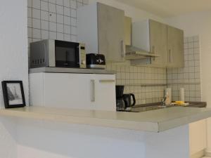 a kitchen with a counter with a microwave and a sink at Monteurwohnung Monti 1 in Saarbrücken