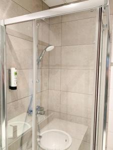 a shower with a glass door next to a sink at Safestay Brussels Grand Place in Brussels