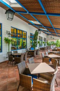 un patio al aire libre con mesas, sillas y ventanas en La Siesta Salou Resort & Camping, en Salou