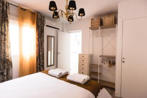 een slaapkamer met een wit bed en een kast bij Apartamento Turístico Mis Rayitos in Córdoba
