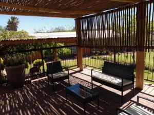 two benches sitting on a patio under a pergola at Wisteria Lane Guesthouse in Postmasburg