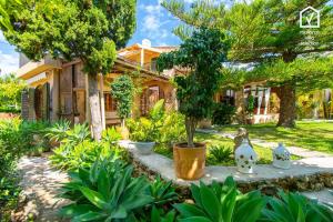 a garden in front of a house at Finca MARIPOSA Alcudia in Alcudia