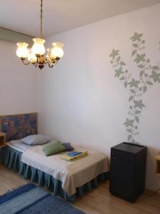 a bedroom with a bed and a chandelier at Hotel Suonenjoki in Suonenjoki