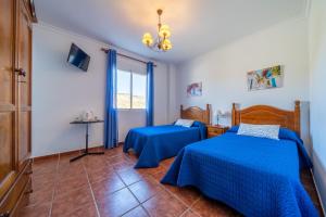 sypialnia z 2 łóżkami i oknem w obiekcie Hostal Vista a la Sierra w mieście Valle de Abdalagís