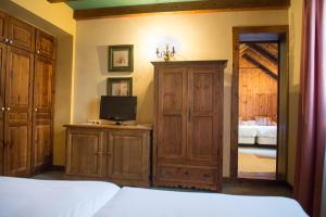 a bedroom with a bed and a tv and a mirror at Hotel Chalet Bassibe by Silken in Baqueira-Beret