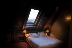 a bedroom with a large bed with a window at Hotel Chalet Bassibe by Silken in Baqueira-Beret