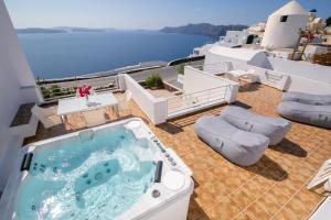 einen Whirlpool auf einer Terrasse mit Meerblick in der Unterkunft Onar Villas - Onar Hotels Collection in Oia