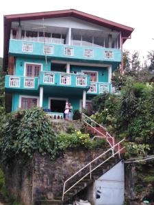 a blue house on top of a hill at Cool Mount Guest in Nuwara Eliya