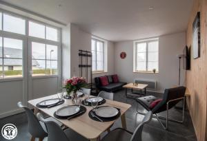 a living room with a dining table and chairs at Gîte de Granit ROSE in Besse-et-Saint-Anastaise +10 photos