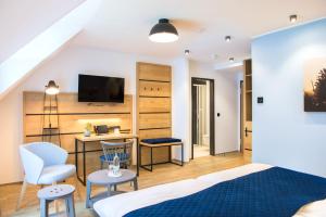 a bedroom with a bed and a desk and a tv at Aktivhotel Inselsberg in Tabarz