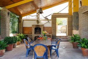 un patio avec une table, des chaises et une cheminée dans l'établissement Loma Méndez Casa 2, à Casarabonela