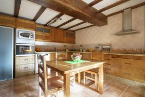 une cuisine avec une table en bois et un vase de fleurs. dans l'établissement Loma Méndez Casa 2, à Casarabonela