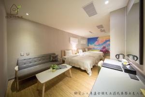 a hotel room with two beds and a couch at Smile 73 Hotel in Taichung