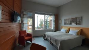 sypialnia z łóżkiem, krzesłem i oknem w obiekcie Jokiniemen Matkailu w mieście Alapitkä