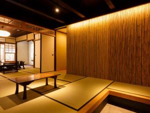 a room with a wooden wall with a wooden table at Tawara-an in Kyoto +6 photos