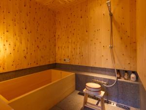 a wooden bathroom with a tub and a toilet at Tawara-an in Kyoto