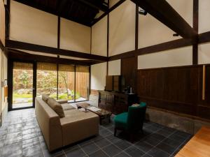 ein Wohnzimmer mit einem Sofa und einem Stuhl in der Unterkunft Tawara-an in Kyoto