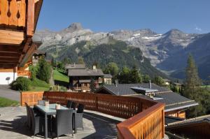 einen Balkon mit einem Tisch, Stühlen und Bergen in der Unterkunft Chalet Edelweiss Breathtaking Glacier View in Les Diablerets