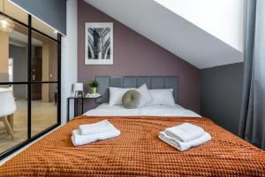 um quarto com uma cama grande com duas toalhas em Friendhouse Residence na Cracóvia