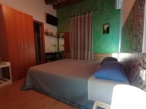 ein Schlafzimmer mit einem Bett und einer grünen Wand in der Unterkunft Donnaciccinatrapani in Rilievo