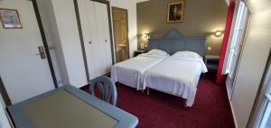 a bedroom with two beds with white sheets and a tv at Metropol in Paris