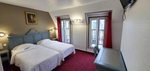 a bedroom with two beds and two windows at Metropol in Paris