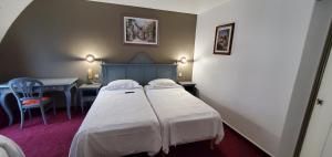 a bedroom with two beds and a desk and a table at Metropol in Paris