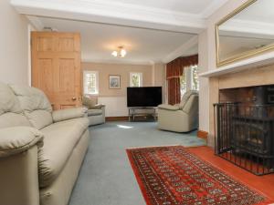 sala de estar con sofá y chimenea en The Croft, en Vowchurch