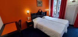 a bedroom with two beds and an orange wall at Metropol in Paris