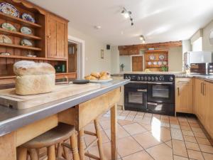 a large kitchen with wooden cabinets and black appliances at The Croft in Vowchurch