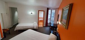 a room with two beds and an orange wall at Metropol in Paris