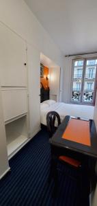 a hotel room with a desk and a bed at Metropol in Paris