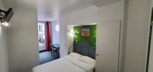 a bedroom with a white bed and a green wall at Metropol in Paris