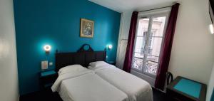 a blue bedroom with a bed and a window at Metropol in Paris